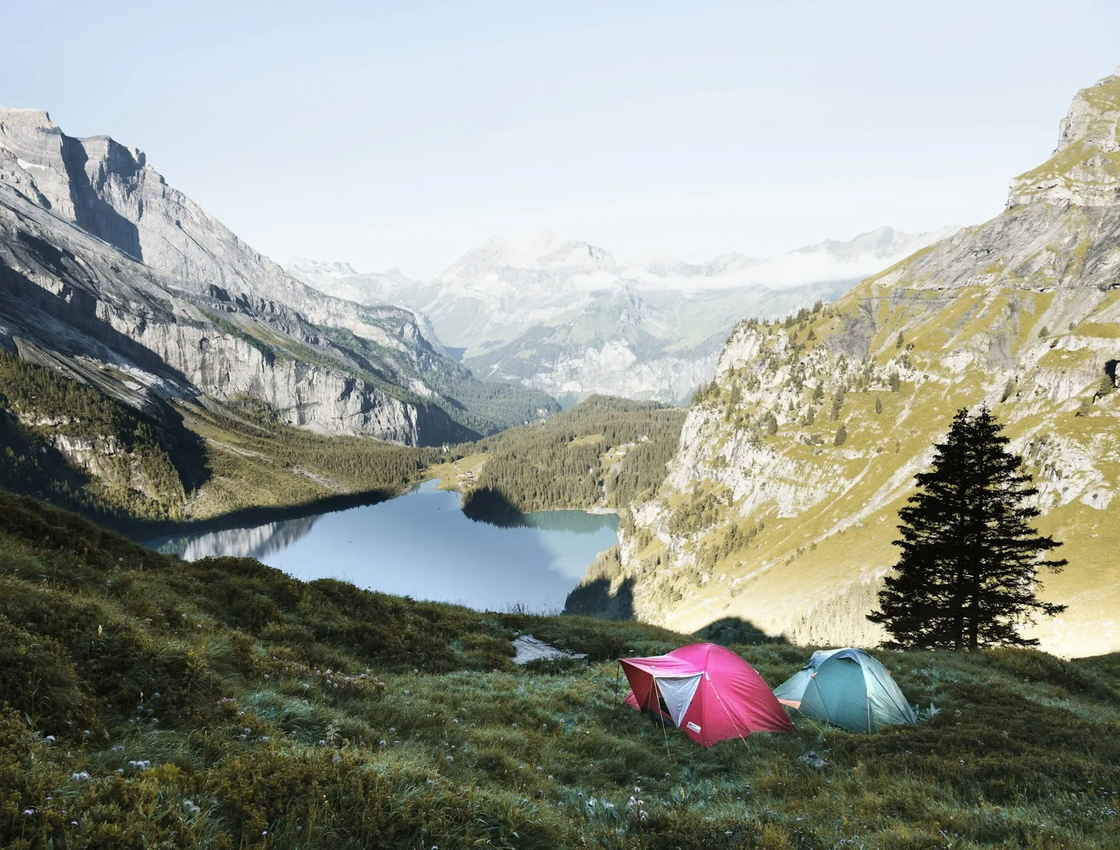 Accessoires de bivouac disposés au sol : frontale, réchaud, gourde, multitool