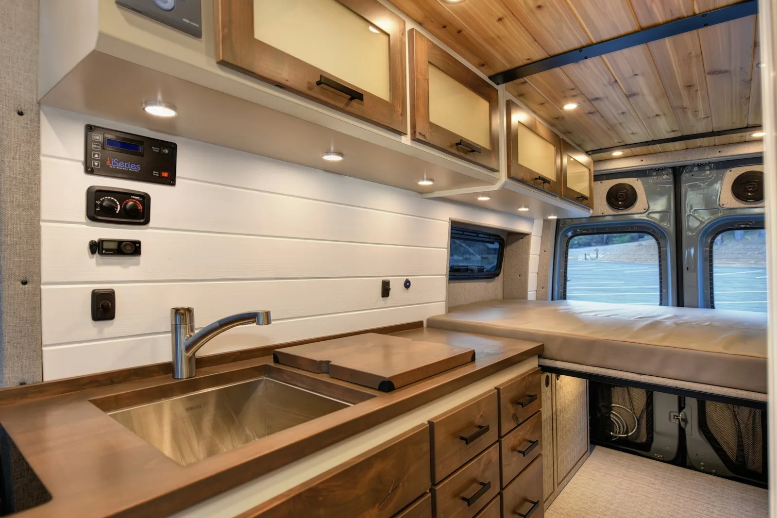 Intérieur d'un van aménagé avec couchage en bois et lumière chaleureuse
