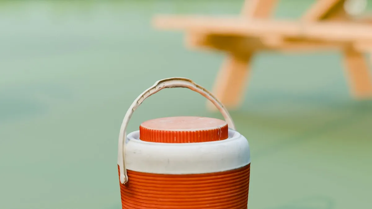 Glacière orange et blanche posée sur l'herbe en extérieur, prête pour le camping