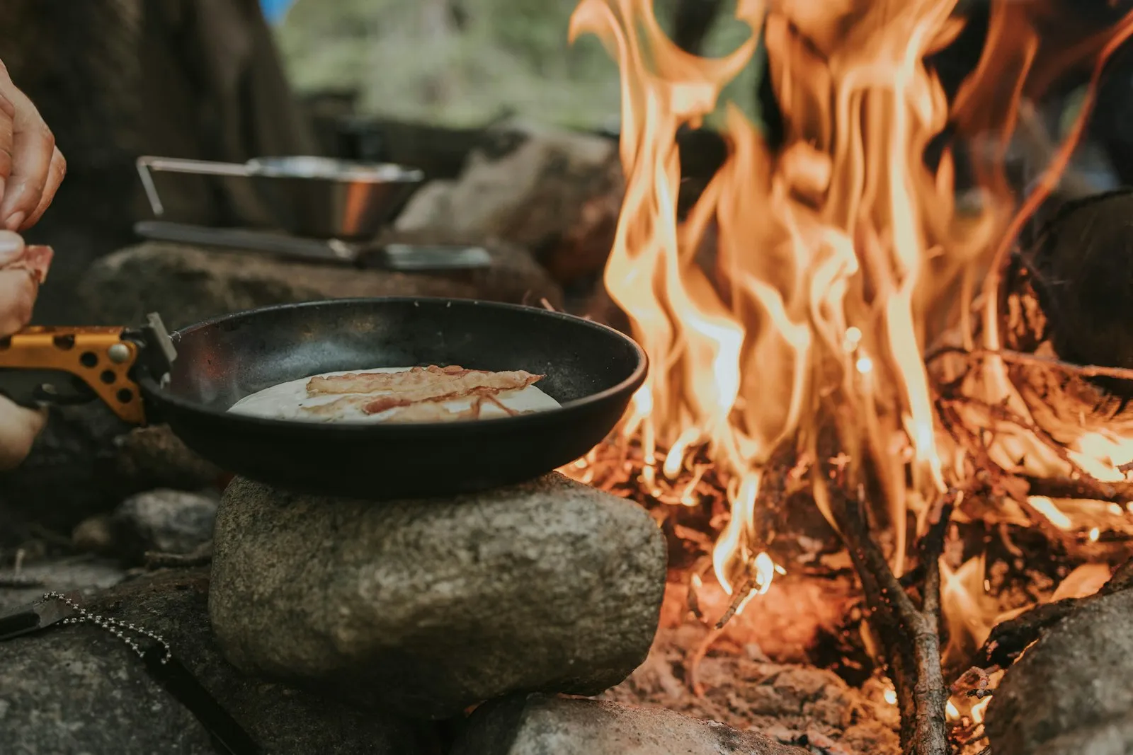 Réchaud de camping allumé avec une popote au petit matin en pleine nature